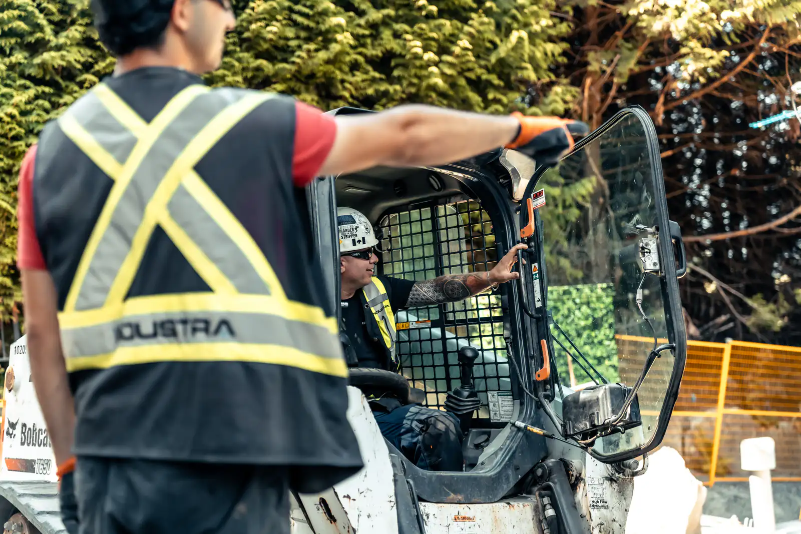A concrete crew working alongside a skid steer on a residential site